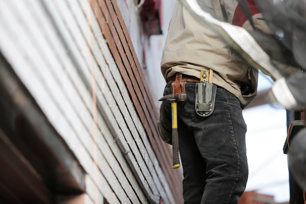 Subcontractor on site wearing a tool belt with hammer - tools and equipment are allowable expenses